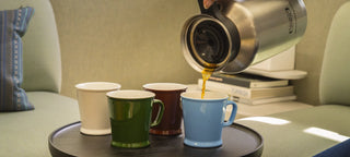 A selection of Acme Union Mugs on a tray in front of a sofa